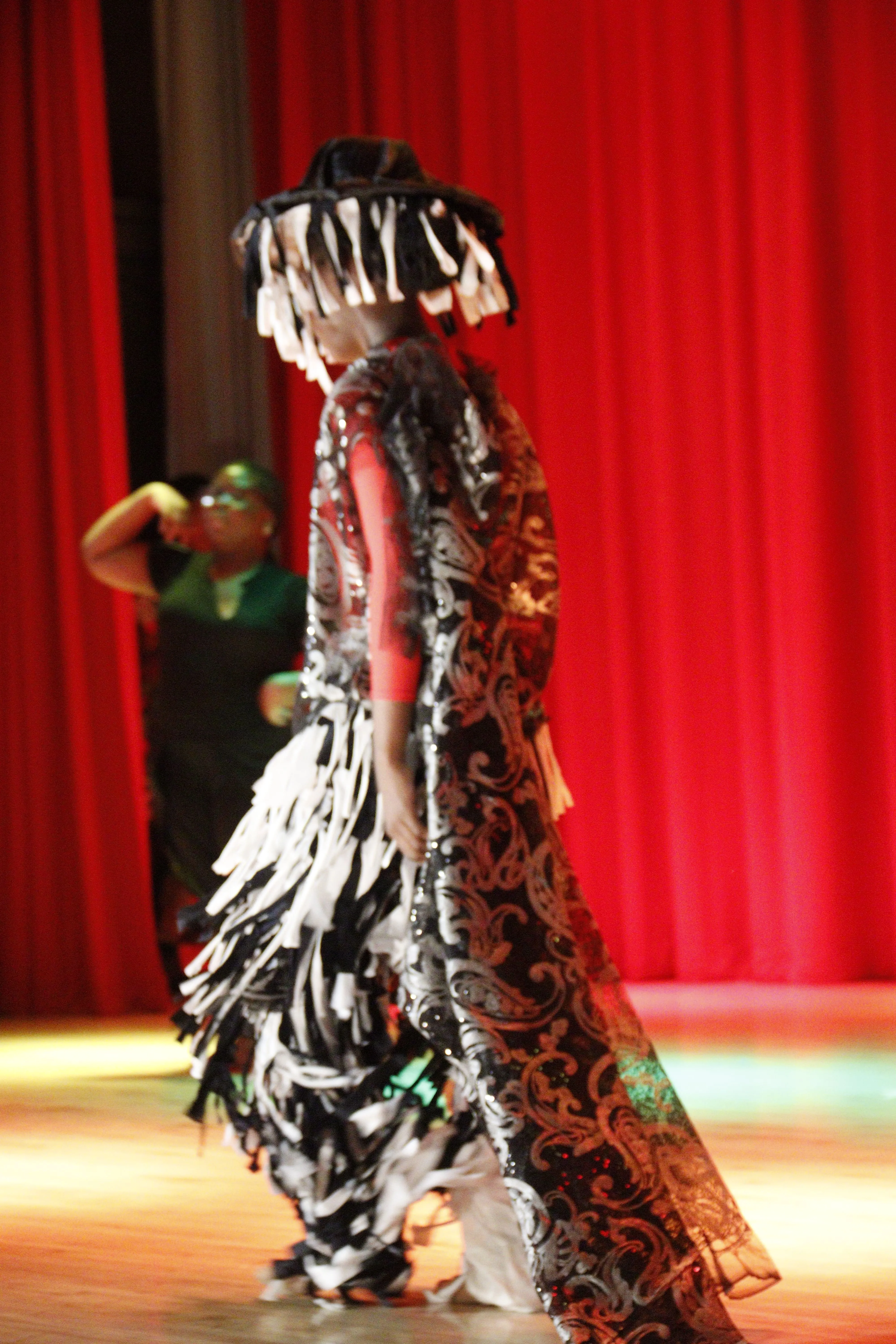 Student in flowing costume performing on stage
