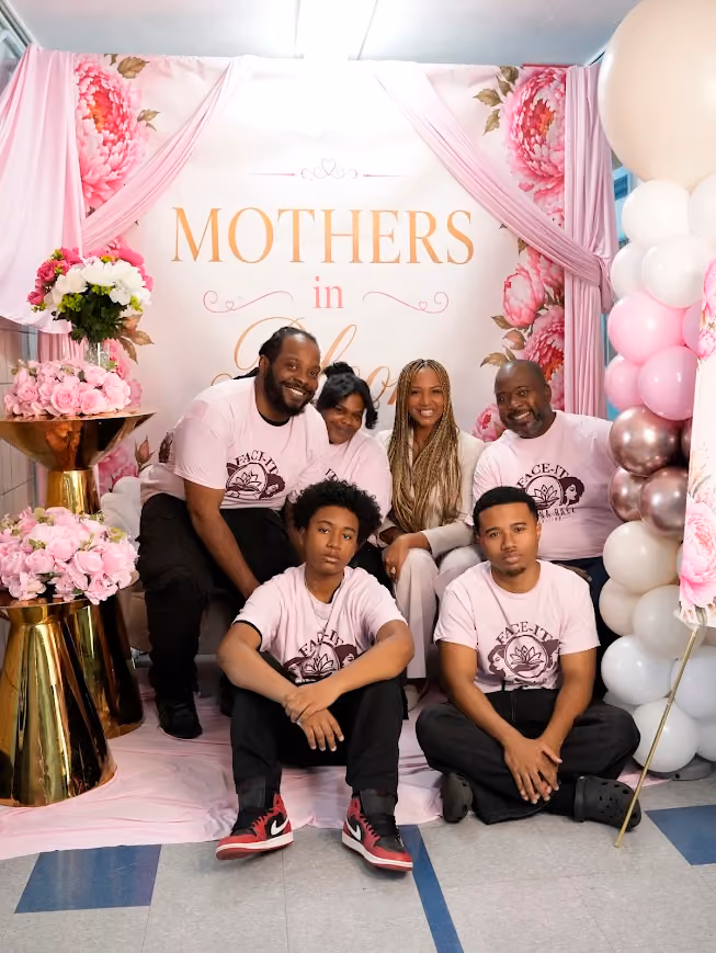 Family posing together at a Mothers in Bloom school event