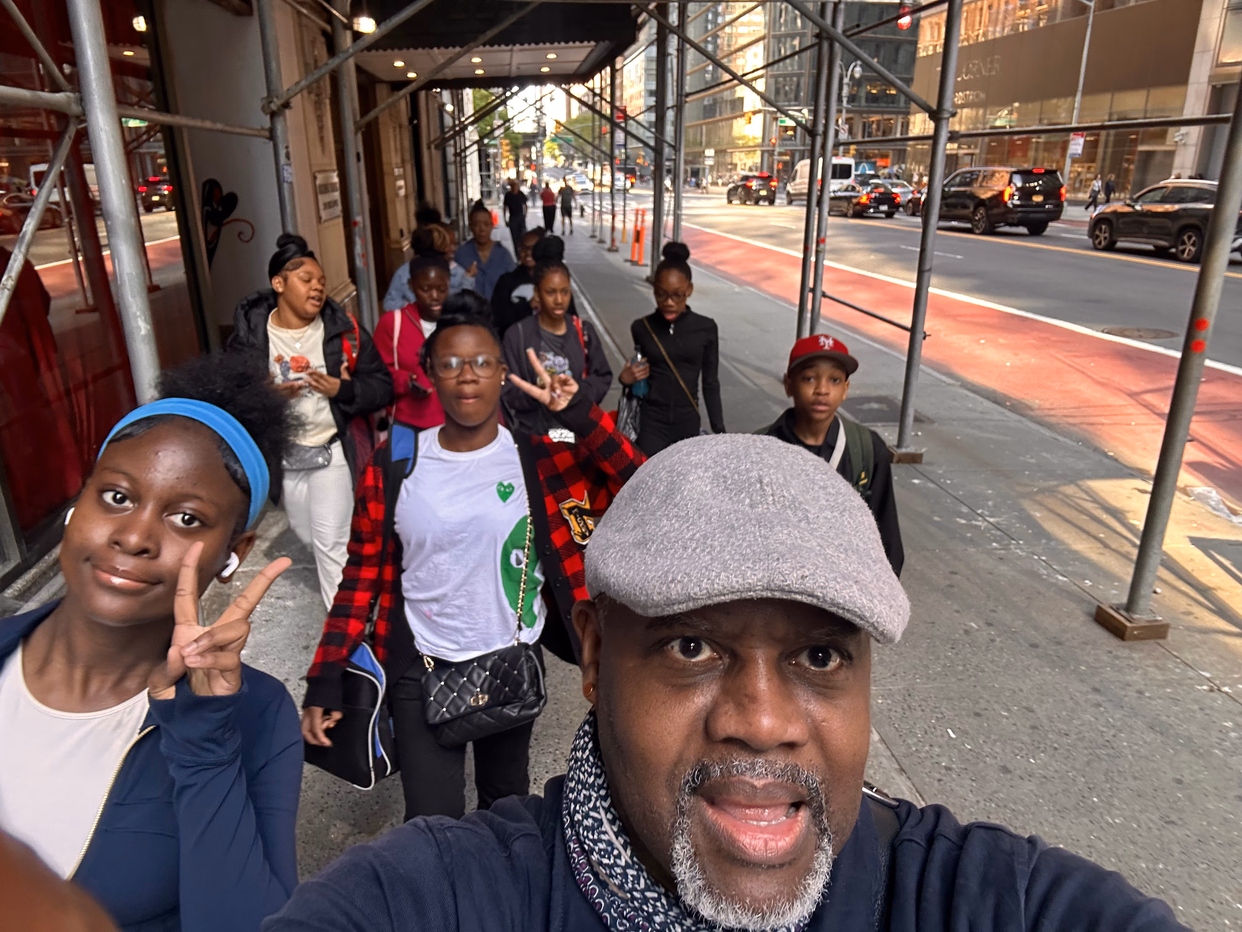 Students and chaperone walking together on a city sidewalk field trip