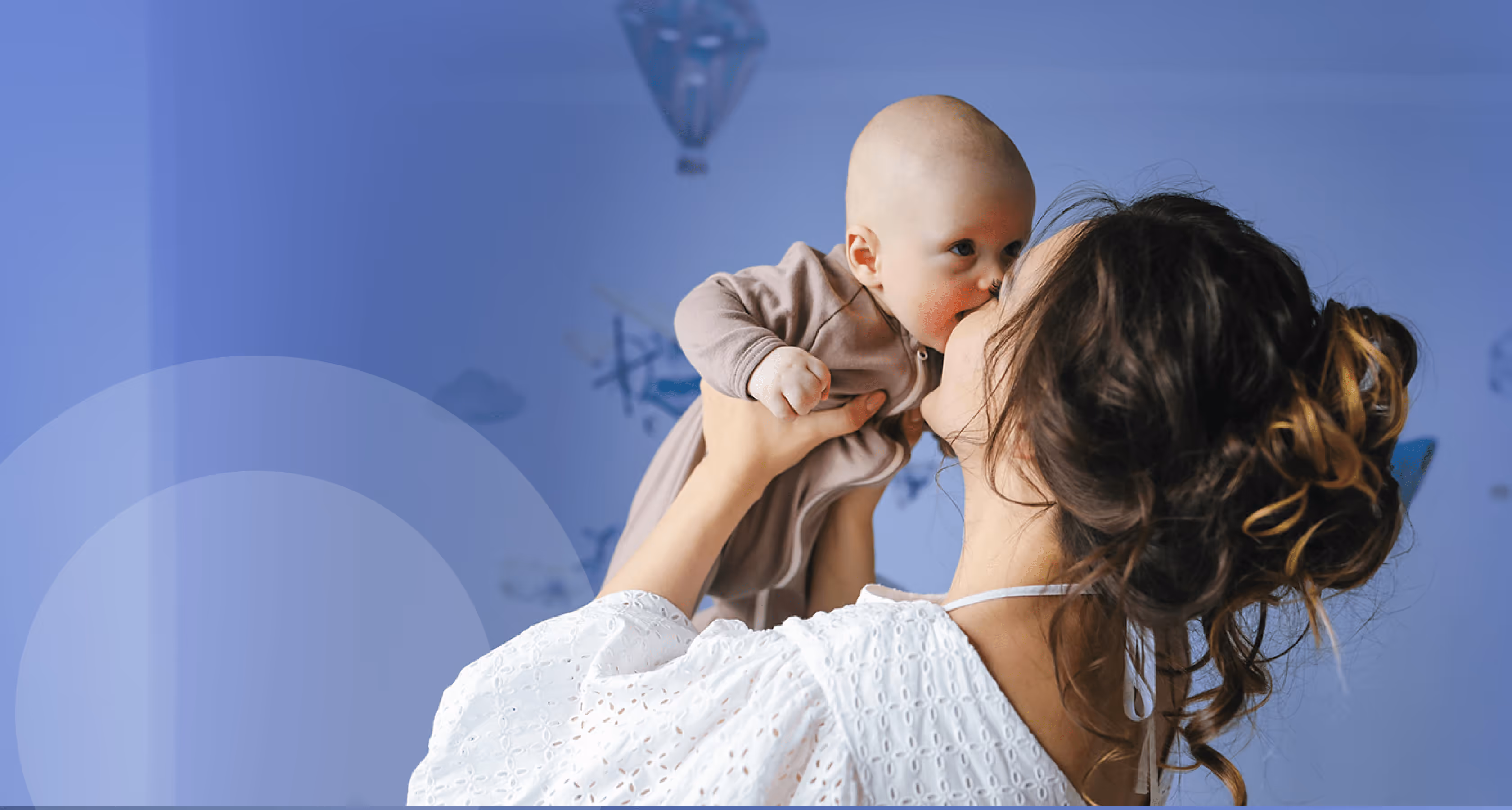 Mother lifting baby and smiling, representing family-building with EggFund