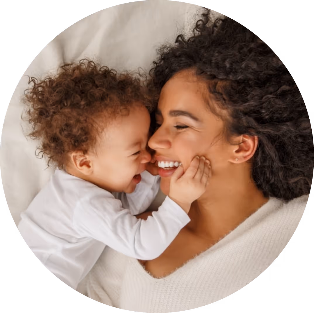 Smiling mother cuddling baby, symbolizing affordable family-building with EggFund fertility loans.