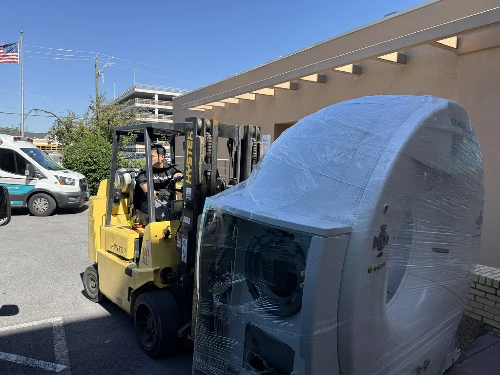 Wrapped CT gantry being handled with a forklift outside Atrium Health Floyd Medical Center.