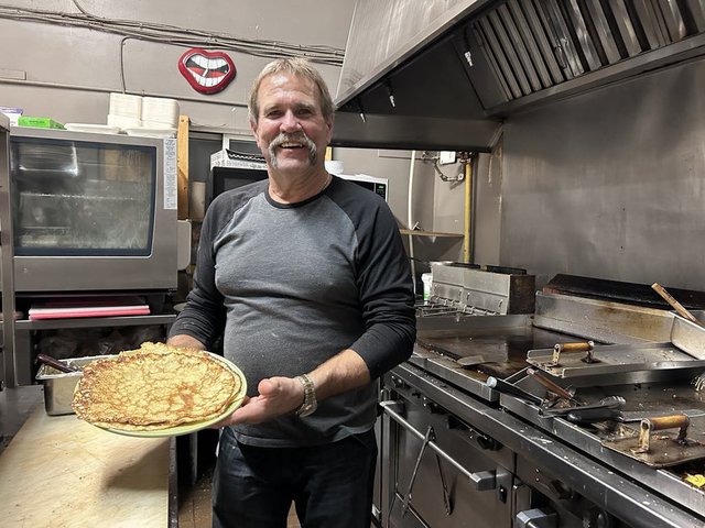 Sweet G’s owner Gord Moir holds his freshly-made Finnish pancakes in Thunder Bay, Ontario.