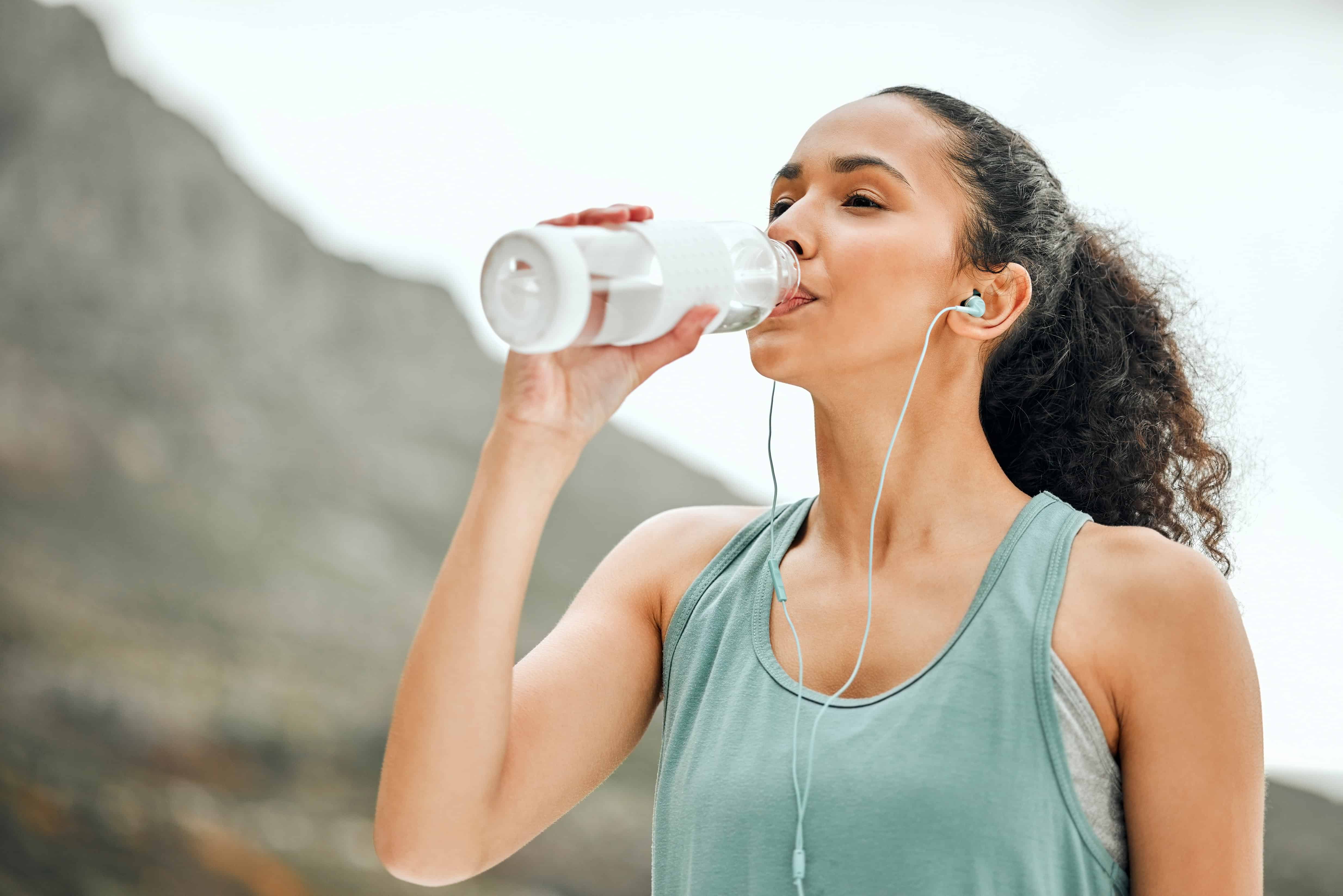 woman drinking from a plastic bottle of water 