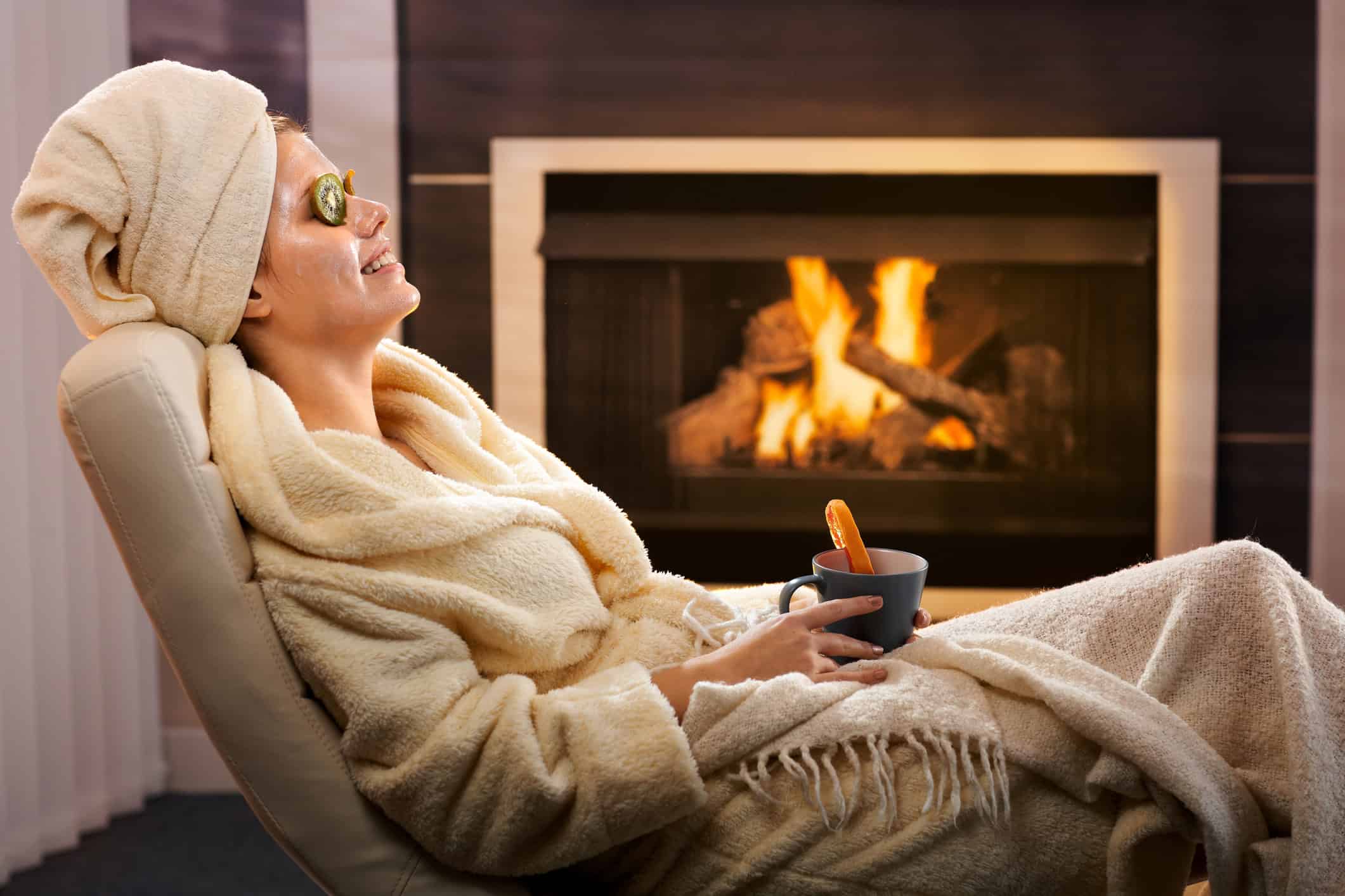 woman relaxing by a fireplace 