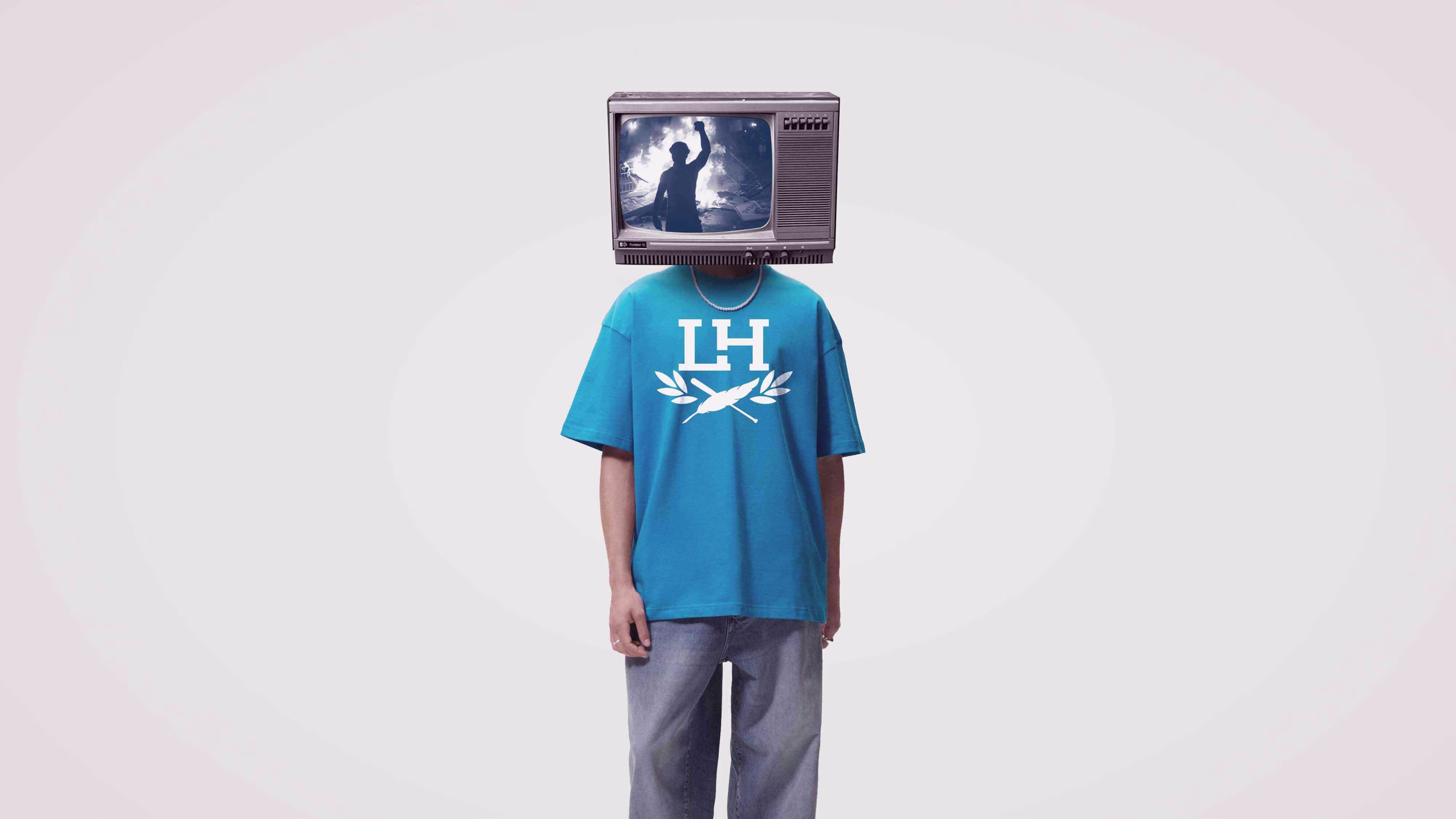 Person wearing blue Liberated Hooligan branded t-shirt with vintage TV head showing protest footage - creative lifestyle photography