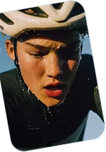 Close-up of a cyclist wearing a helmet and sweating, focused during an intense ride.