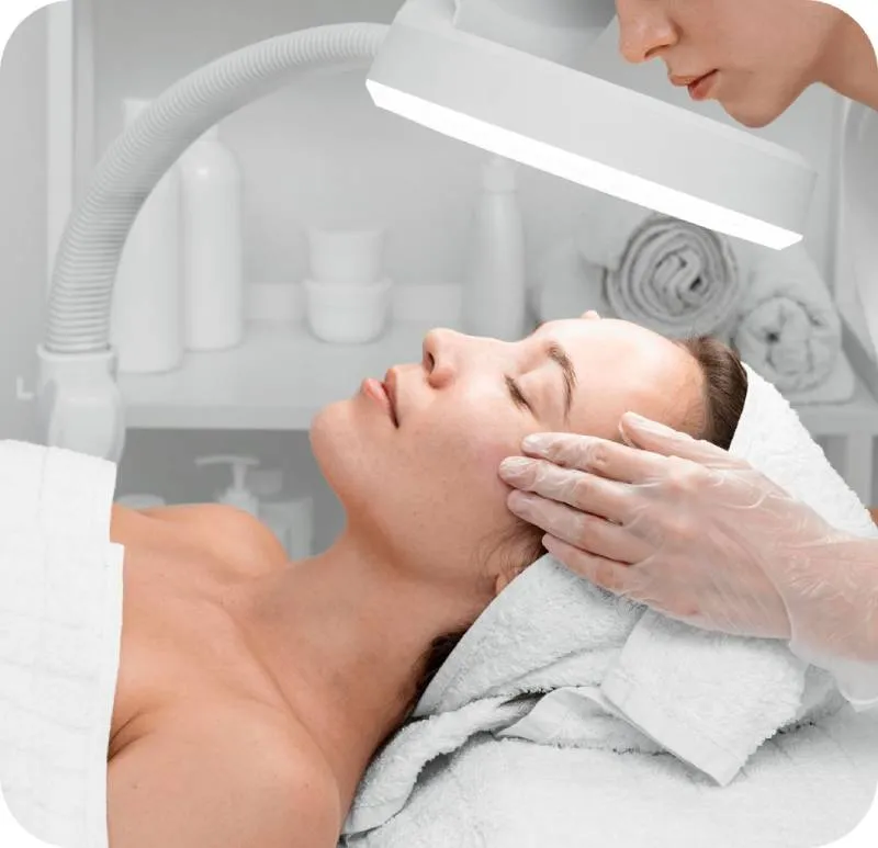 a photo of an esthetician analyzing customer's face skin under the magnifying glass equipment