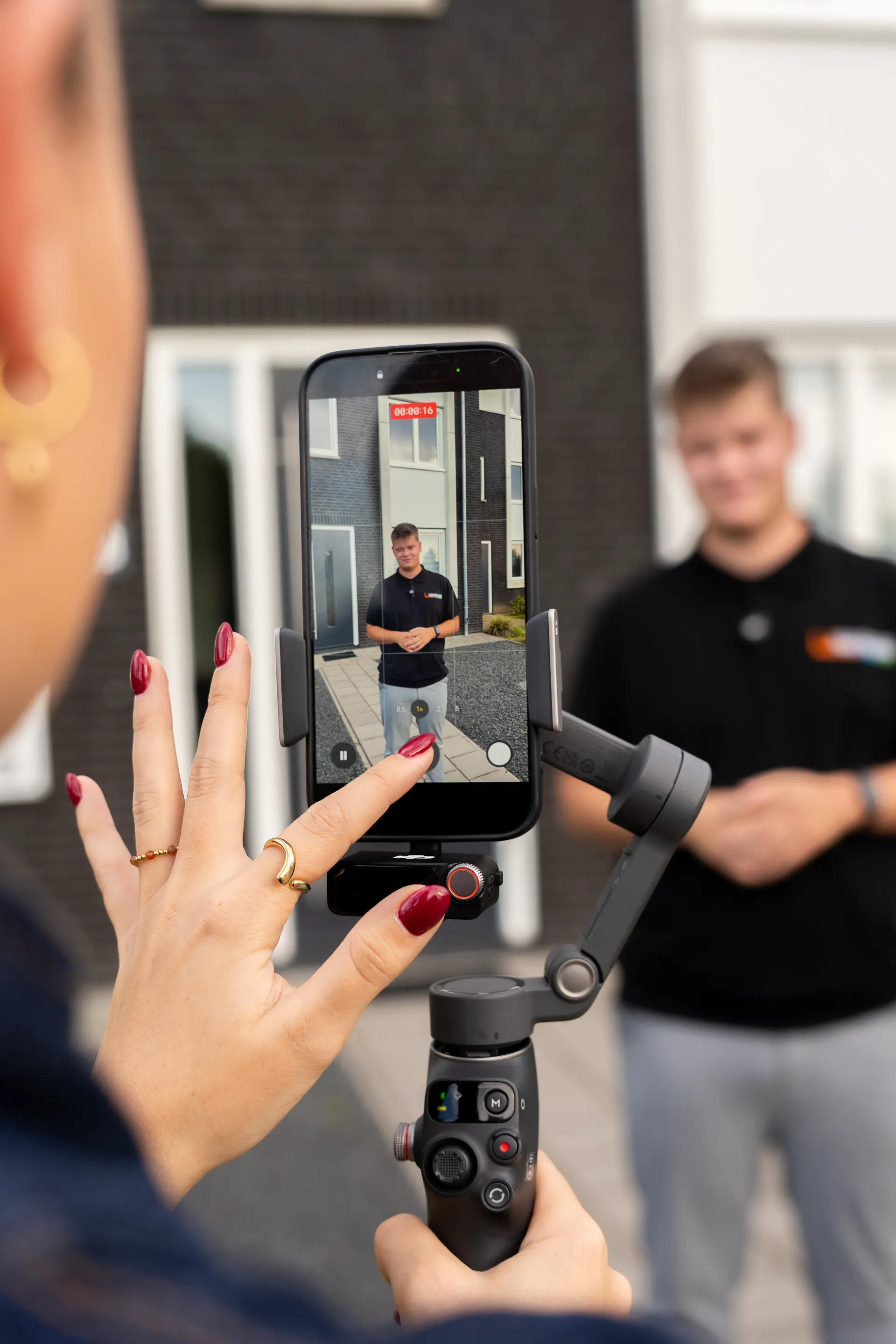 Collega van de Zakerij filmt een medewerker op locatie met een telefoon op een gimbal