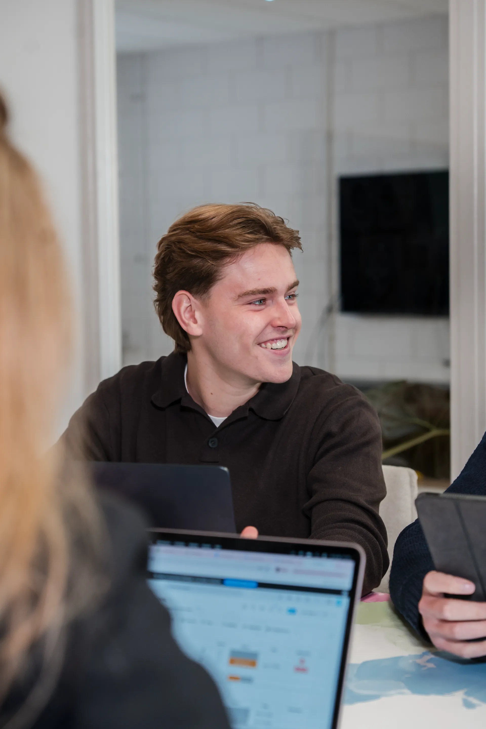Collega van de Zakerij lacht tijdens een overleg aan tafel