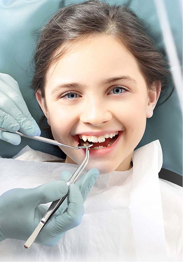 Lächelndes Mädchen bei einer zahnärztlichen Untersuchung, das mit zahnmedizinischen Instrumenten behandelt wird.