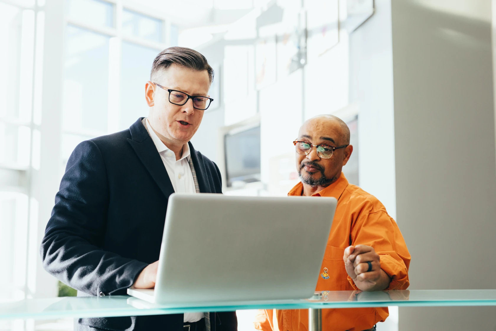 Two men watching a laptop