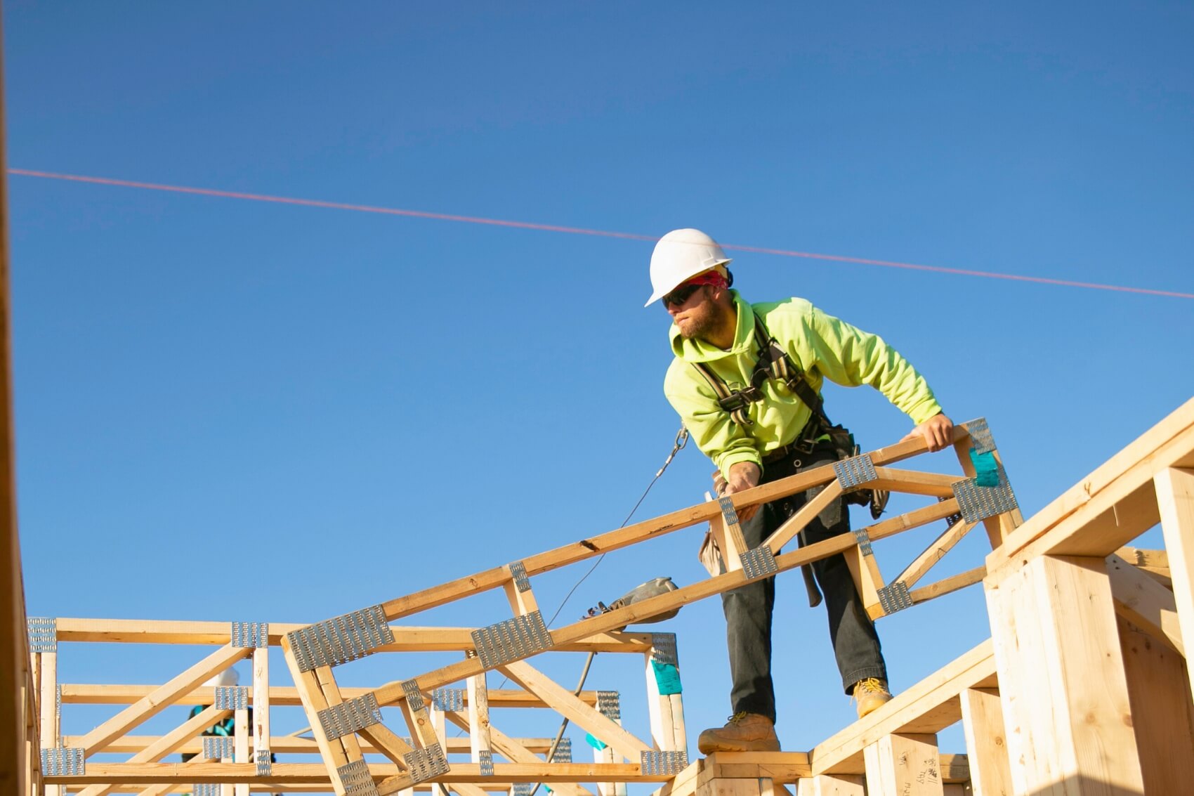 A QBC commercial framer setting a roof truss