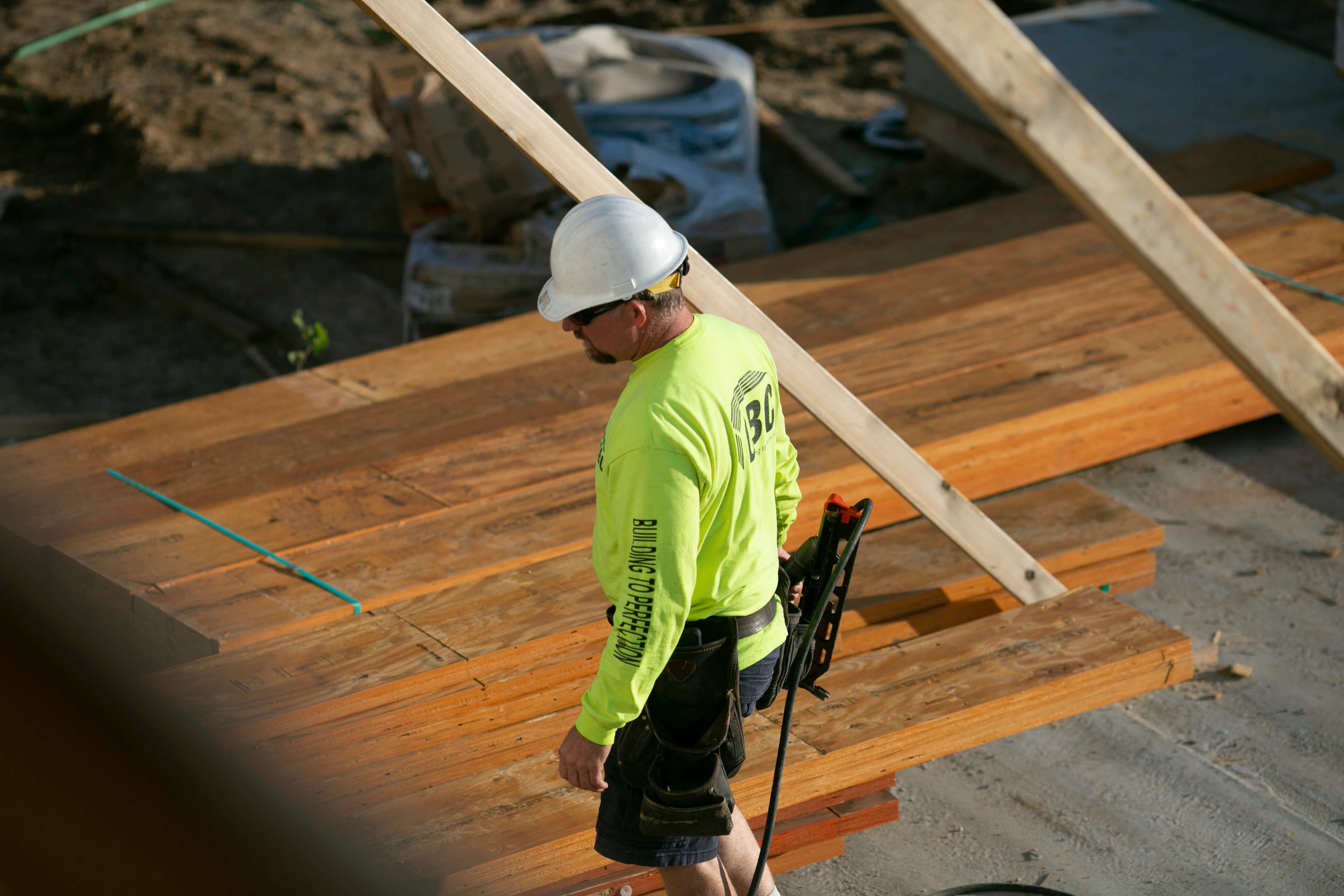 A construction PM inspects lumber before building a multifamily wall panel in DeForest, Wisconsin.