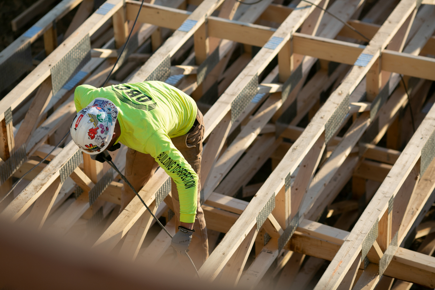 A QBC framer rigging a cable on a floor truss package so the panels can be craned into place on a multifamily project in Wisconsin