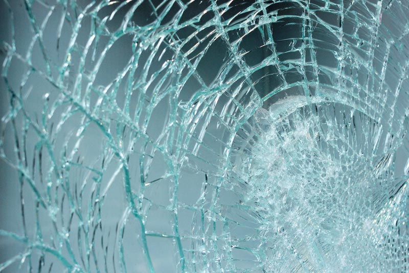 Gebroken ruit met een spinnenweb van barsten