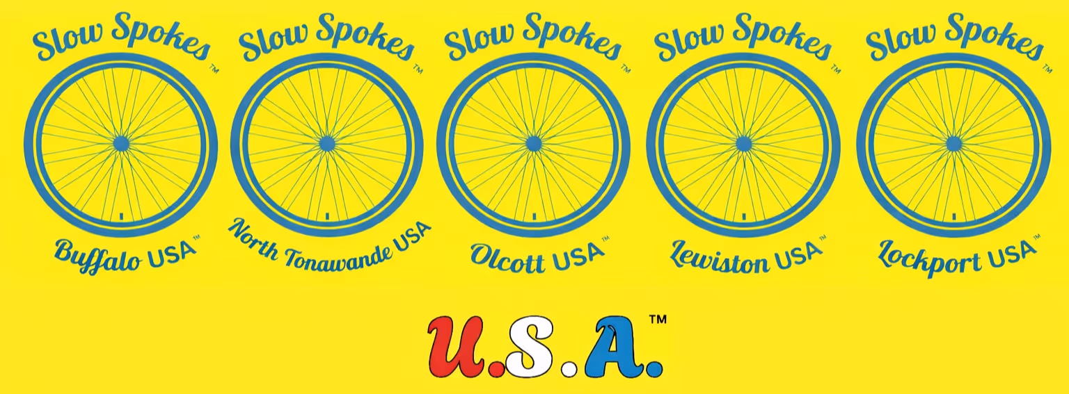 Five blue bicycle wheel logos with the text Slow Spokes and city names Buffalo, North Tonawanda, Olcott, Lewiston, Lockport USA on a yellow background, with U.S.A. in red, white, and blue letters below.