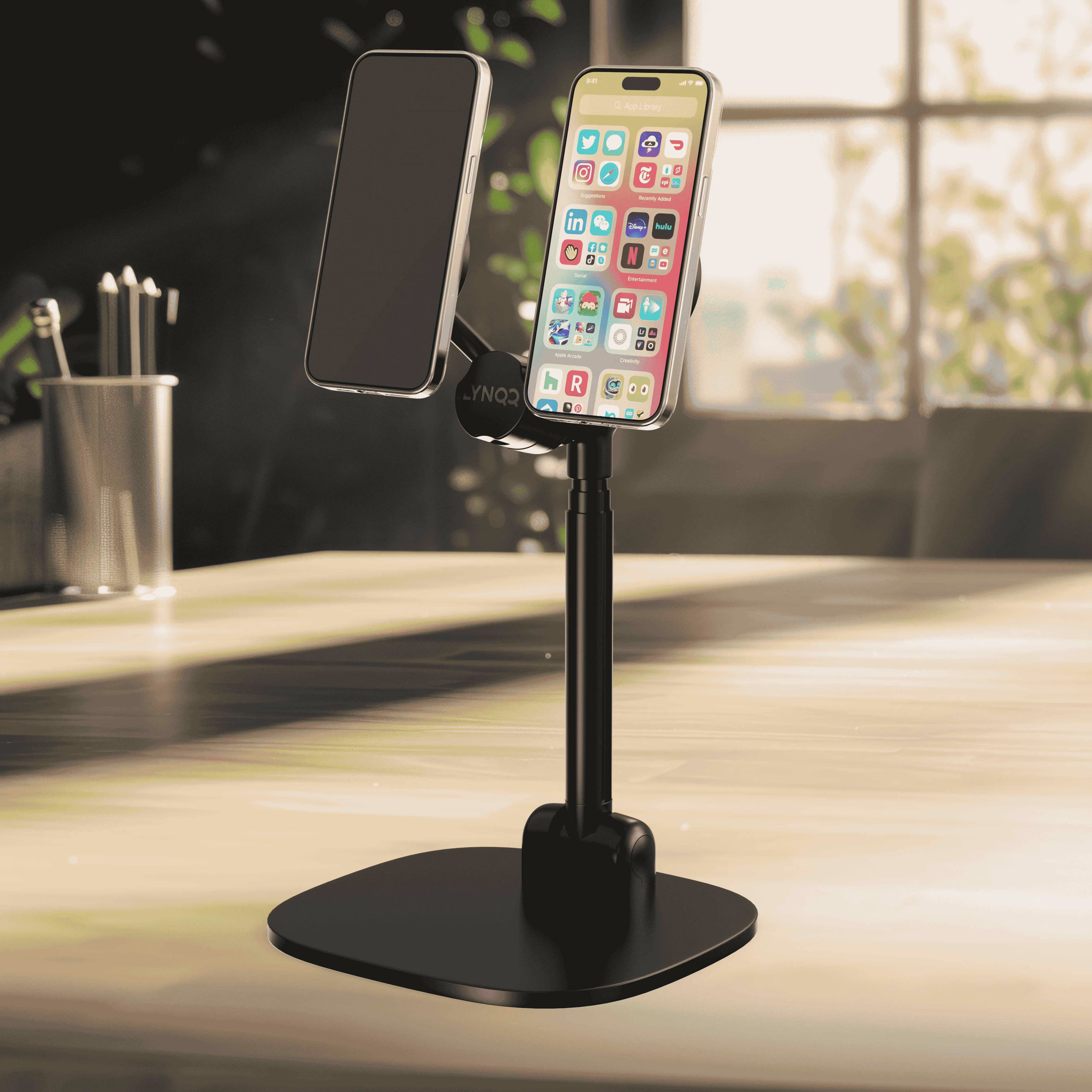 Adjustable phone stand holding smartphone with app icons on desk