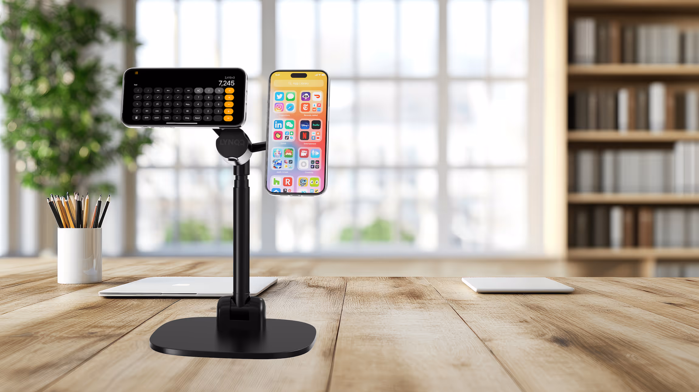 Phone and calculator on adjustable stand near window with pencils