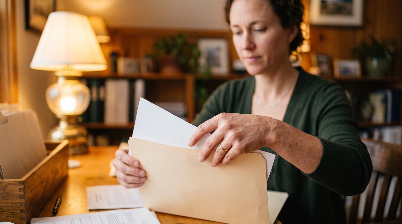 Agent organizing paperwork into folders at a desk
