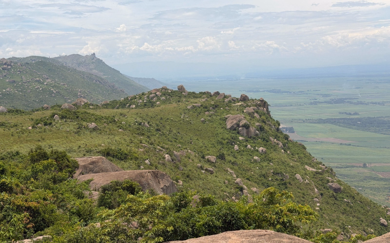 Aerial view from a mountain summit overlooking a green valley and farmland near Old Bonjoge, Kenya.
