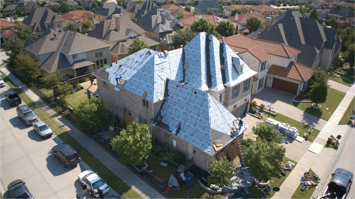 Residential roofing team completing shingle installation