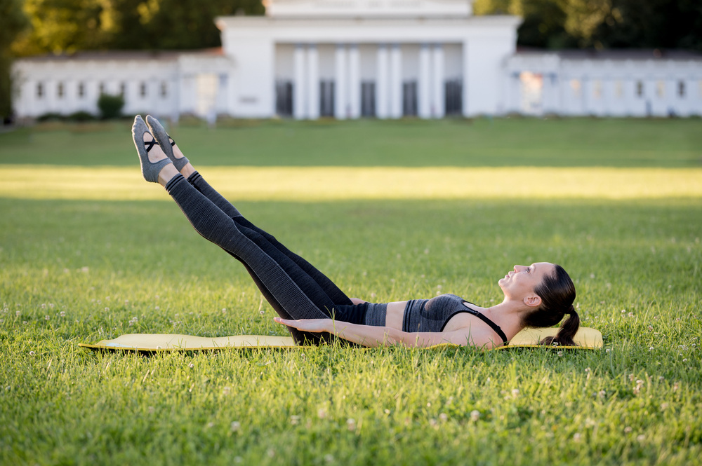 Frau macht den Hundert Pilates Move