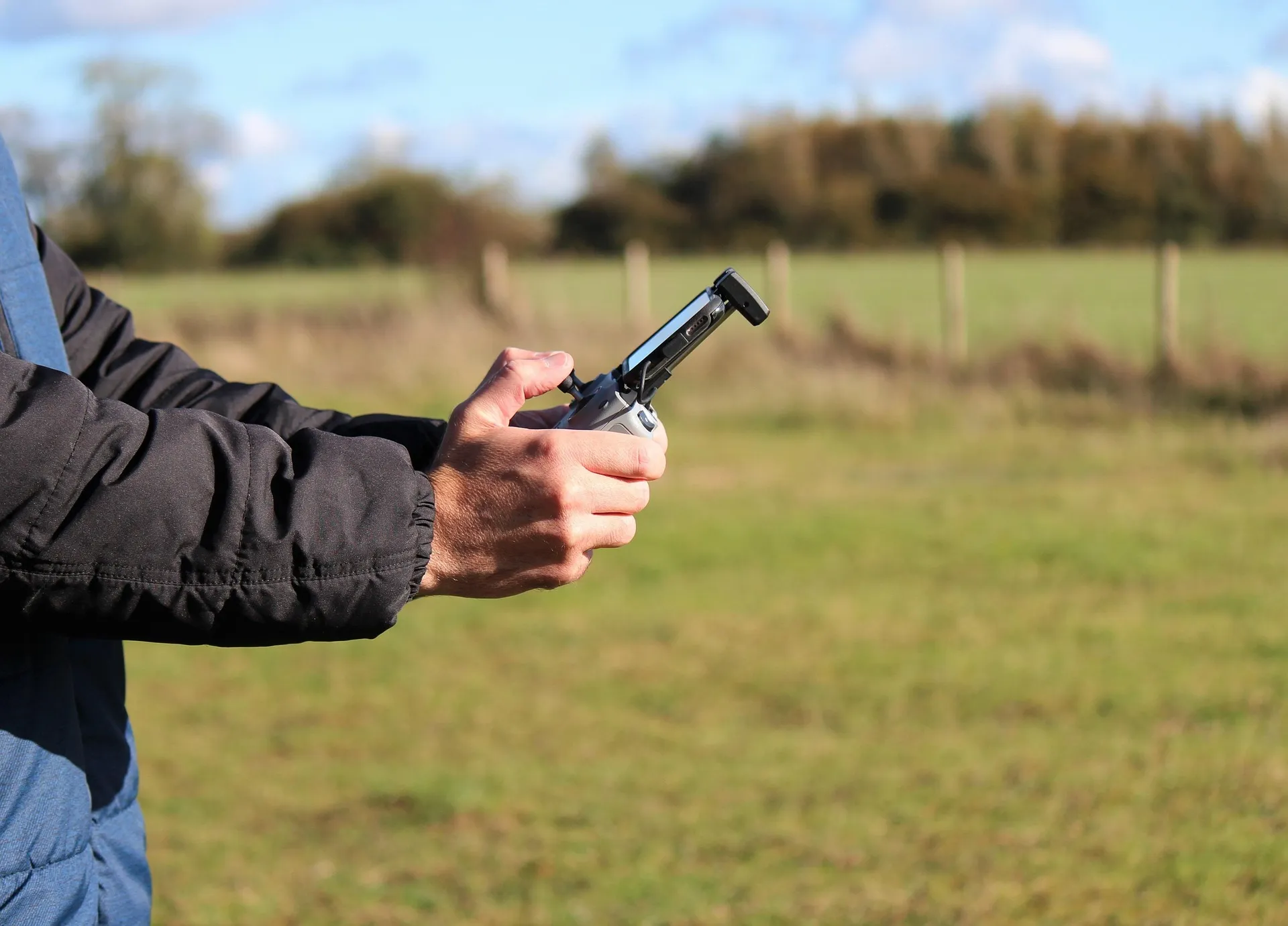 飛手手持遙控器專注於戶外飛行訓練。無人機術科測驗科目「矩形航線飛行」操作示範，針對航線規劃與飛行路徑保持之教學說明。