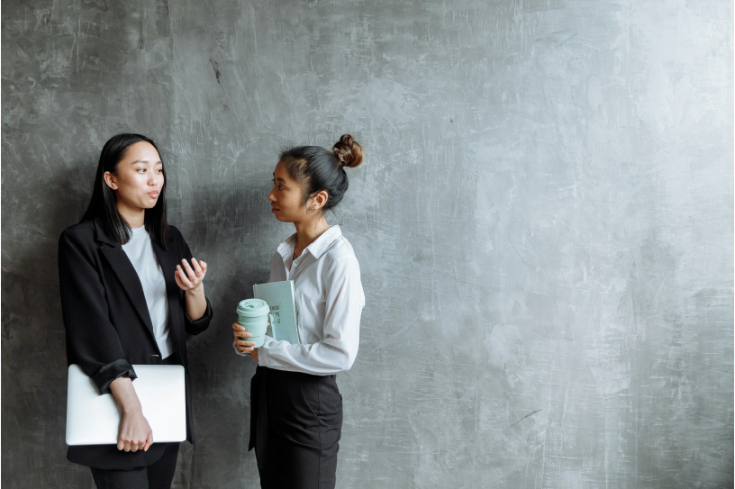 Two businesswomen in a quiet conversation at work