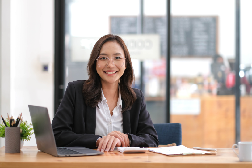 Smiling businesswoman at a laptop in a bright office