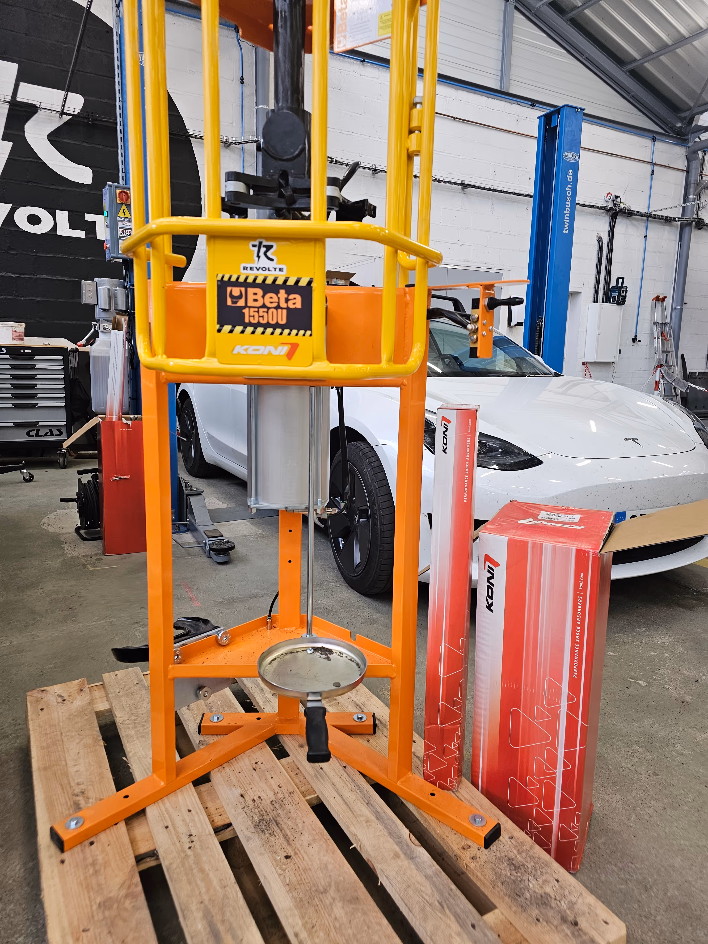 Amortisseurs Koni installés sur un Tesla Model S blanche dans un atelier Revolte