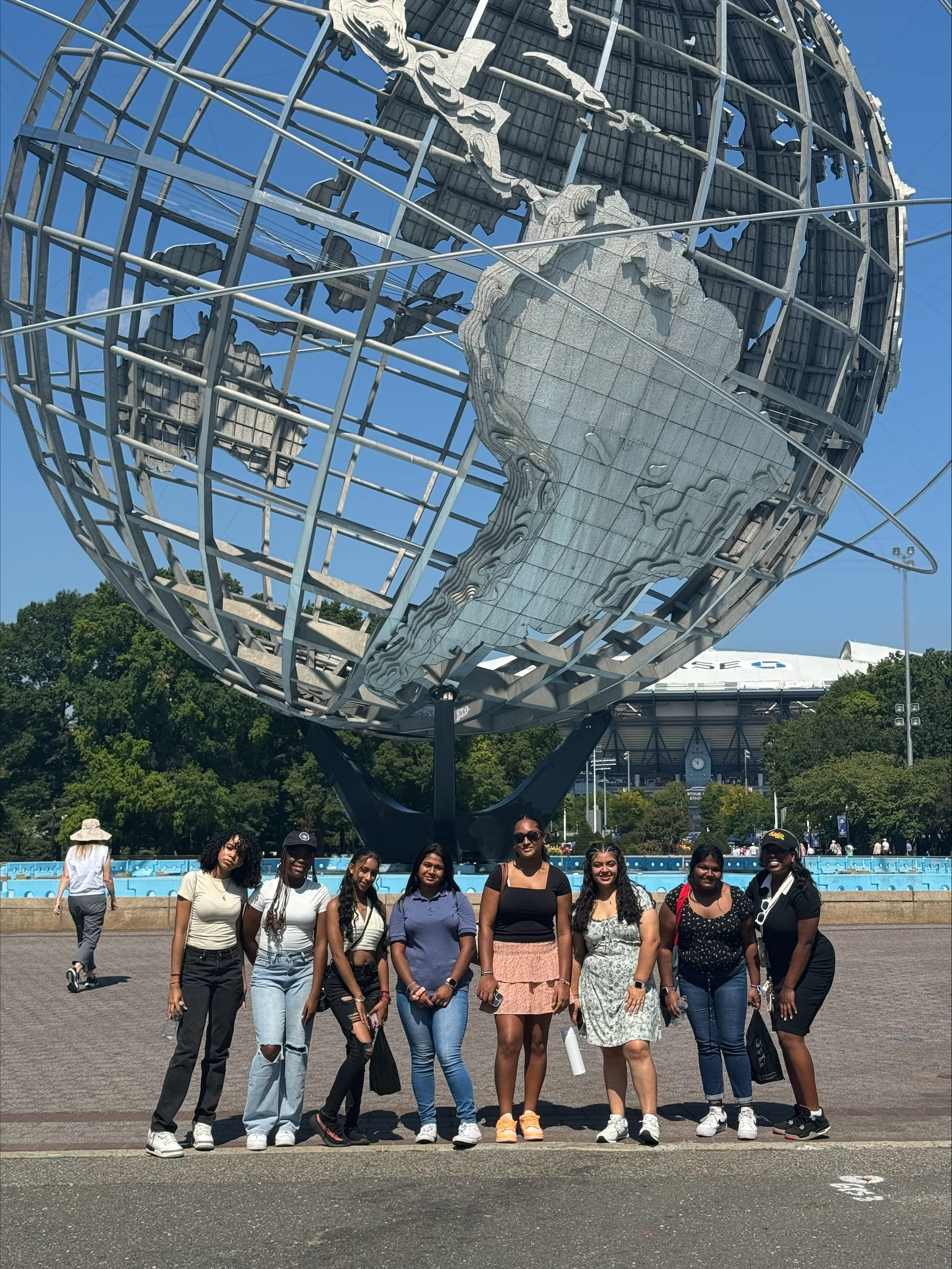 Students posing in front of the Unisphere sculpture in Queens New York