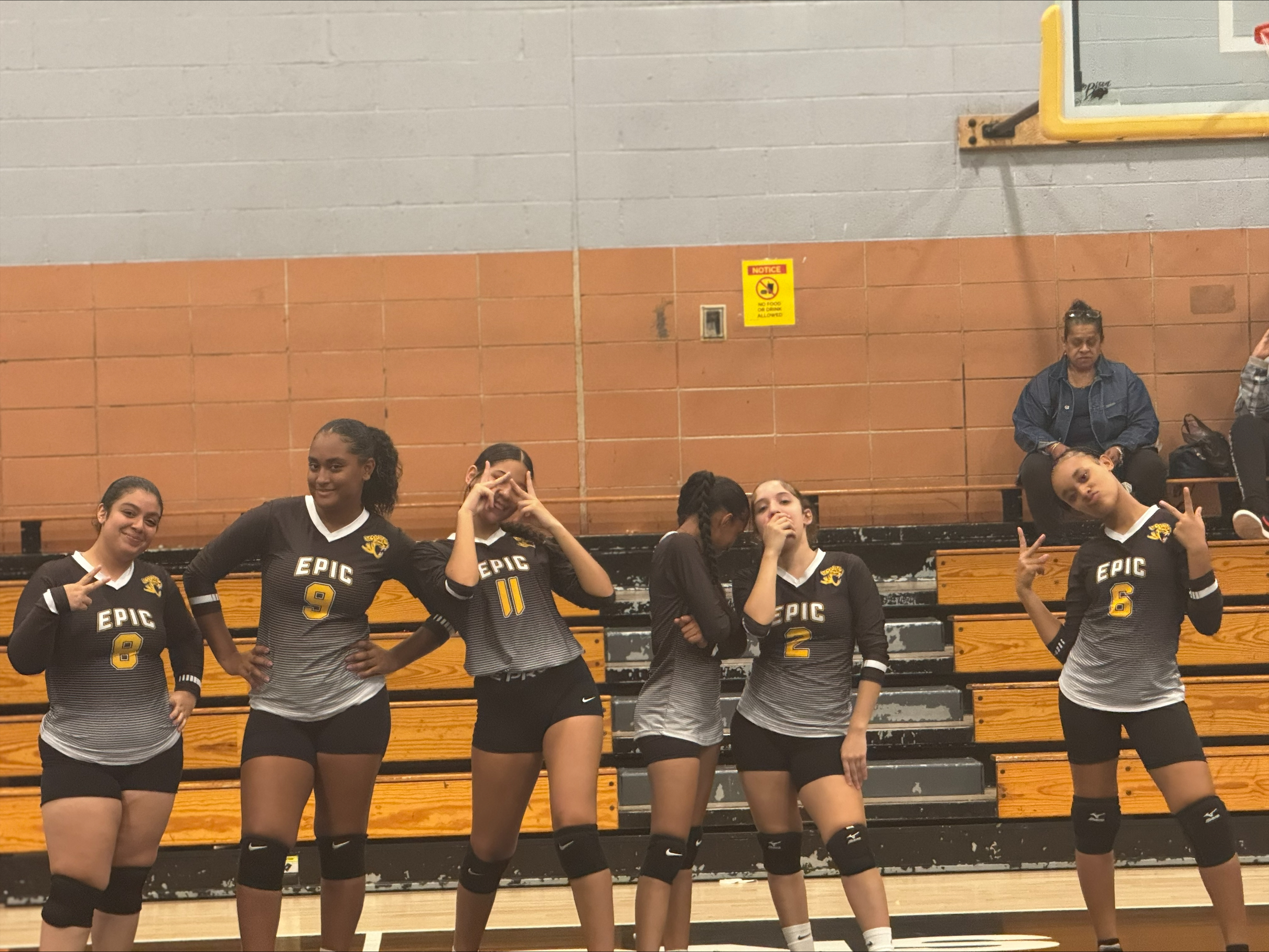 Epic High School South volleyball team posing together in gym