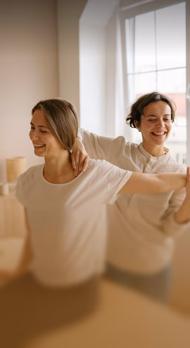Physiotherapist assisting a woman in stretching her arm and shoulder during a therapy session.
