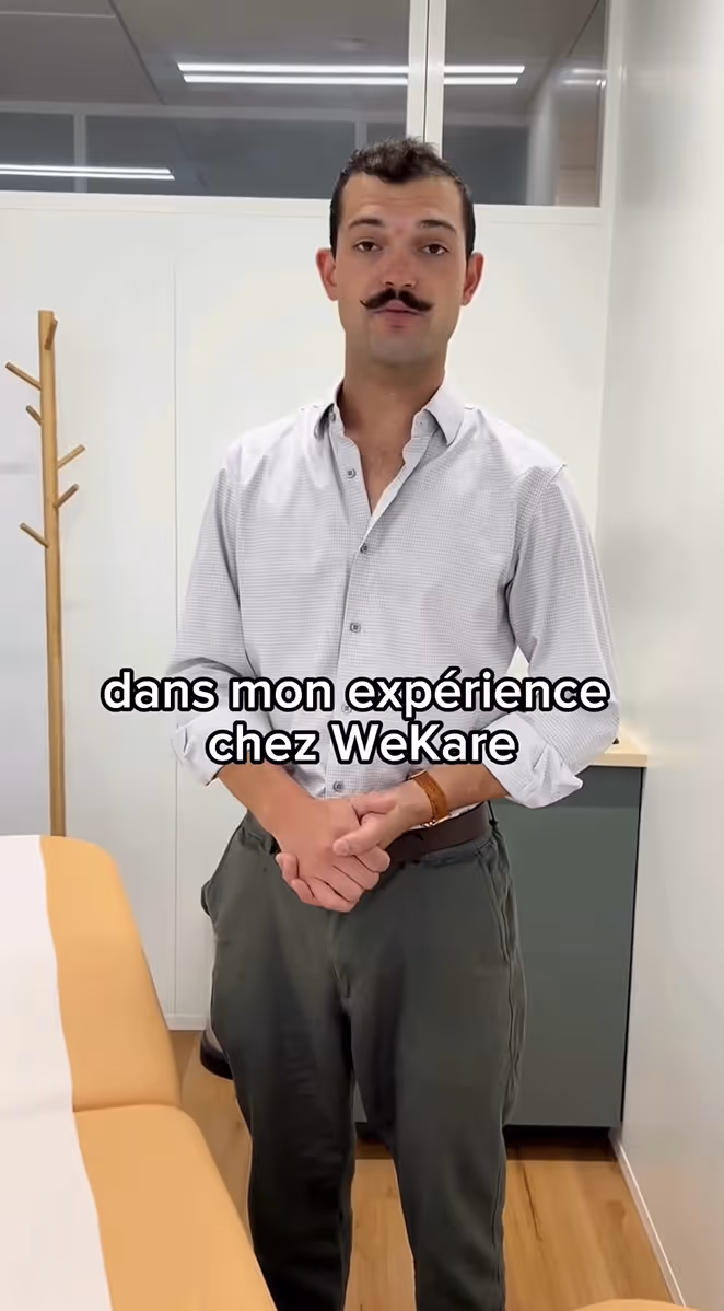 Smiling female doctor wearing white coat and blue gloves examining a patient's head.