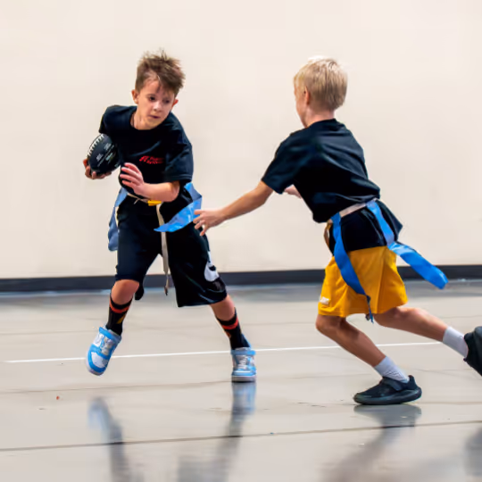 Kid running with a football while dodging