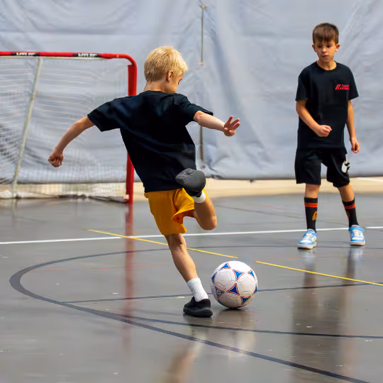 Kid scoring soccer ball