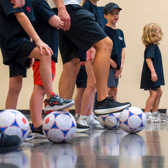Kids with foot on soccer ball