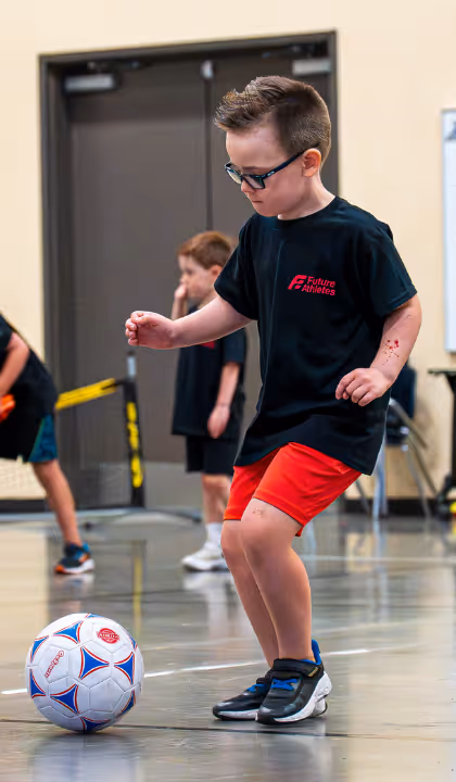 Kid about to kick a soccer ball