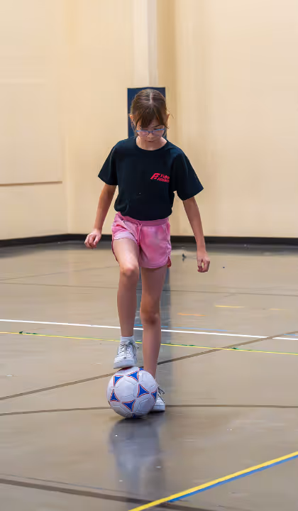 Girl with foot on soccer ball