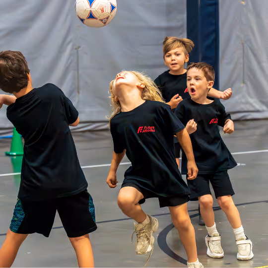 Kid looking at soccer ball in the air