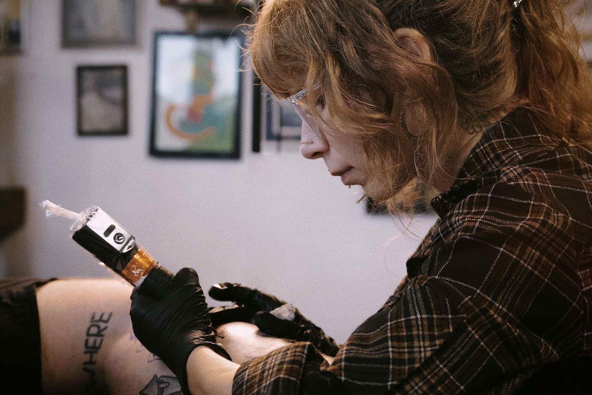 Tattoo artist preforming the tattoo