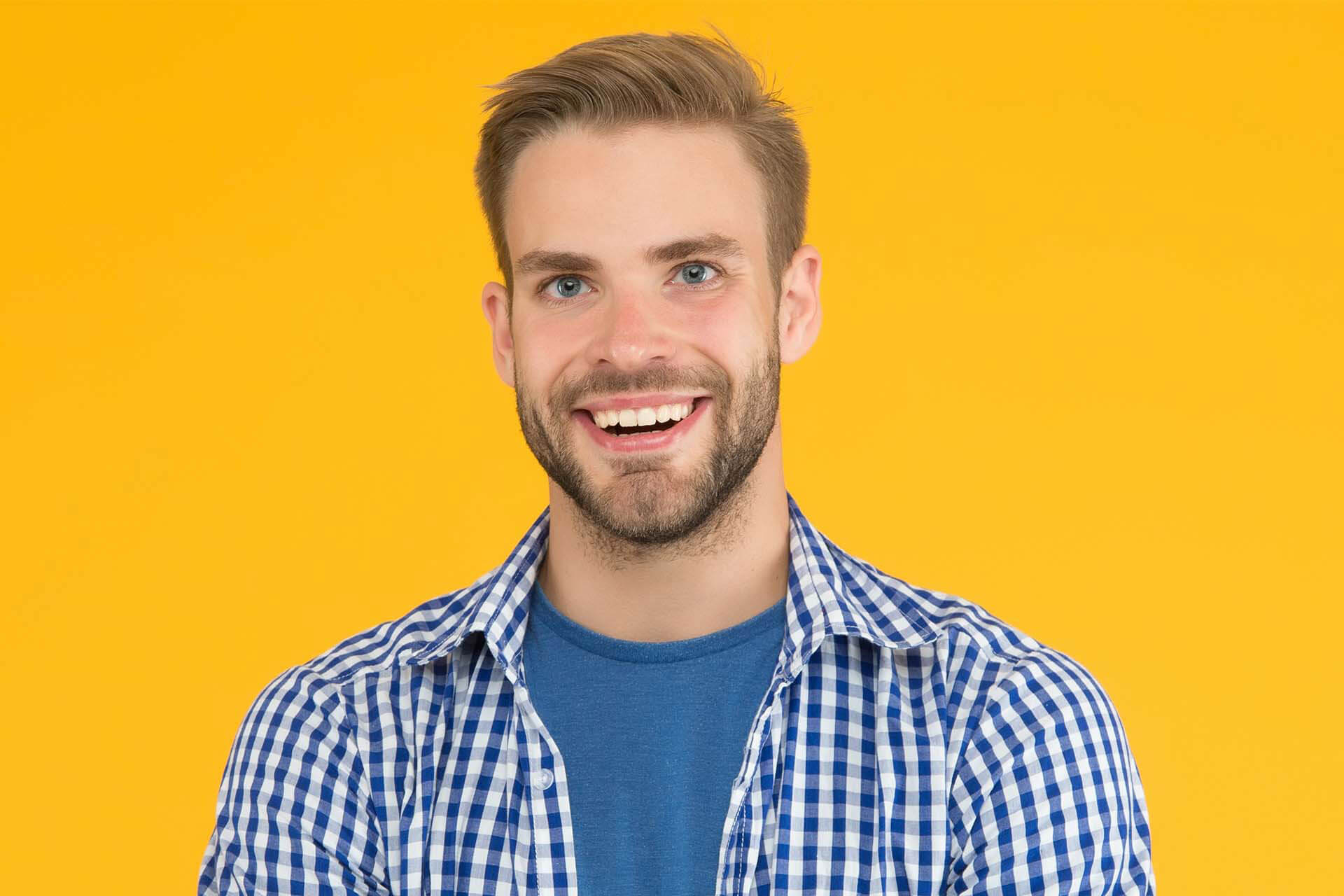 A man with a beard is smiling for the camera.
