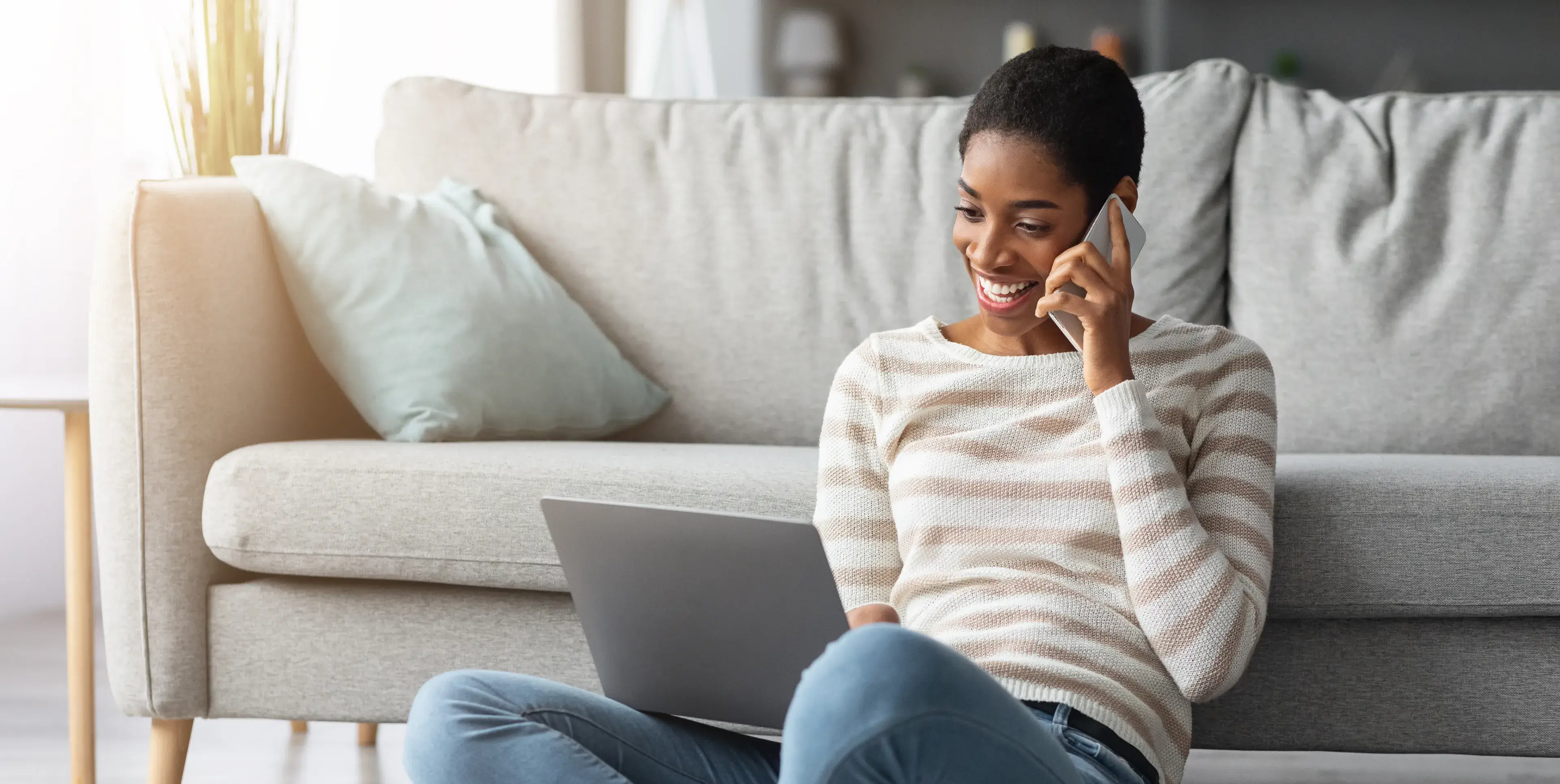 A woman sitting on a couch talking on a cell phone.