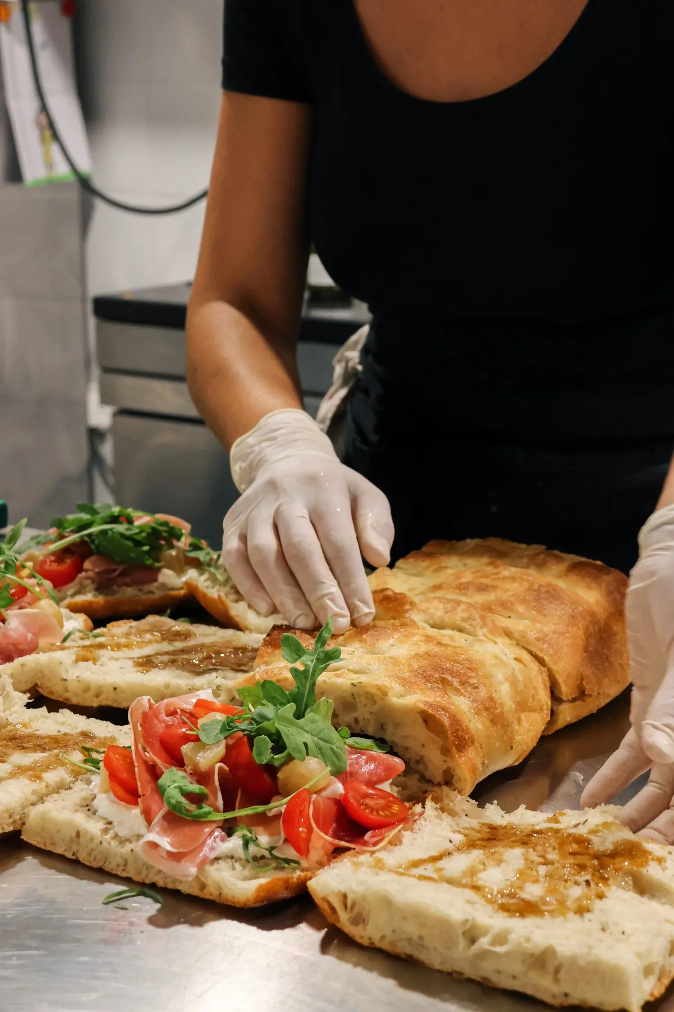 Notre chef cuisinière préparant plusieurs focaccias estivales sur son plan de travail