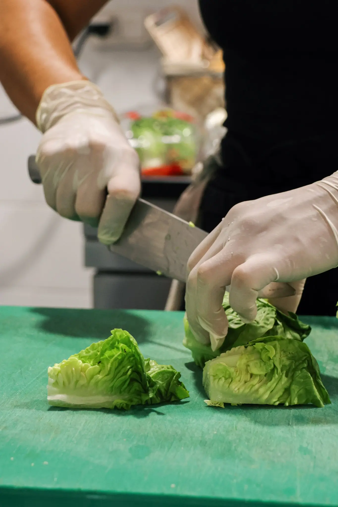 Notre chef cuisinière découpant des feuilles de salade sur son plan de travail