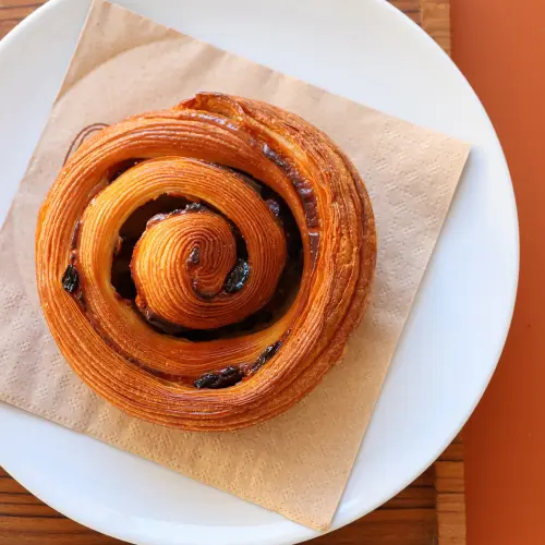 Un pain au raisin pris en photo de haut et posé sur une serviette en papier