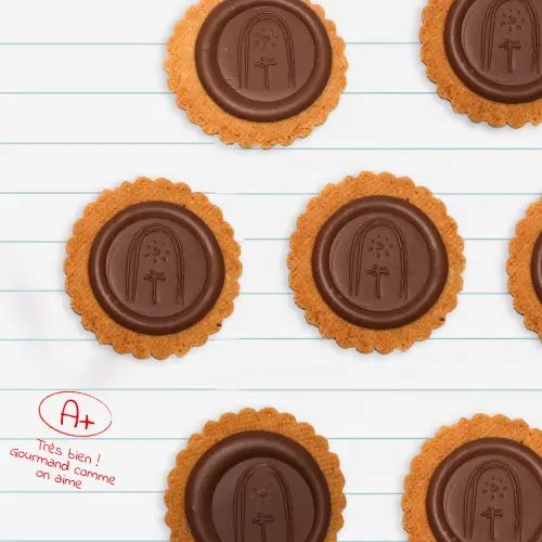Plusieurs sablés « Crokito pur beurre » posés sur une feuille en papier, avec la note A+ écrite à côté