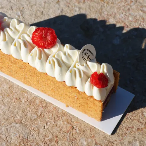 ⁠Patisserie végétale prise en photo de haut avec des morceaux de framboises sur le la crème