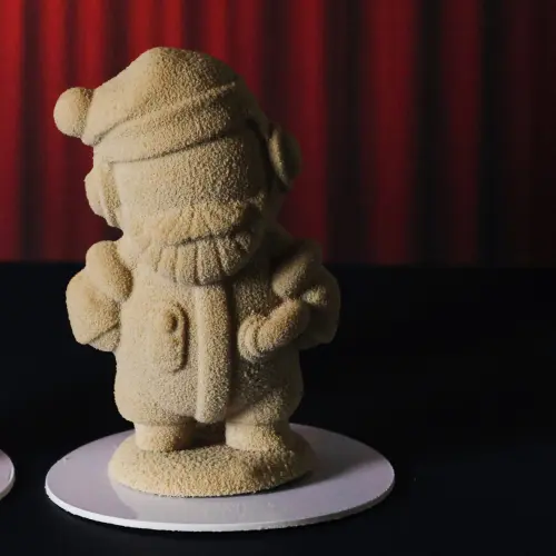 Zoom sujet en chocolat blond Père Noël devant rideau rouge